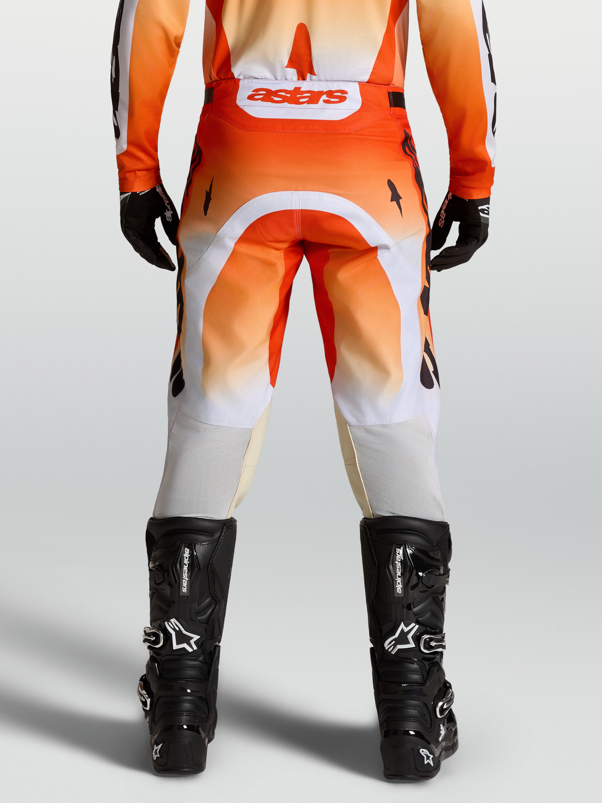 Alpinestars Racer Amber Pants, red and white motocross pants shown from the rear on-model with black boots.