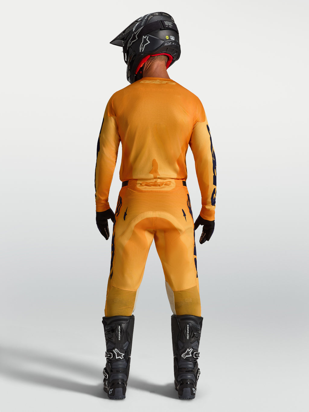 Alpinestars 2027 Racer Amber trøje og udstyrssæt, herre-motocrosstøj i orange og mørkeblå, set bagfra.