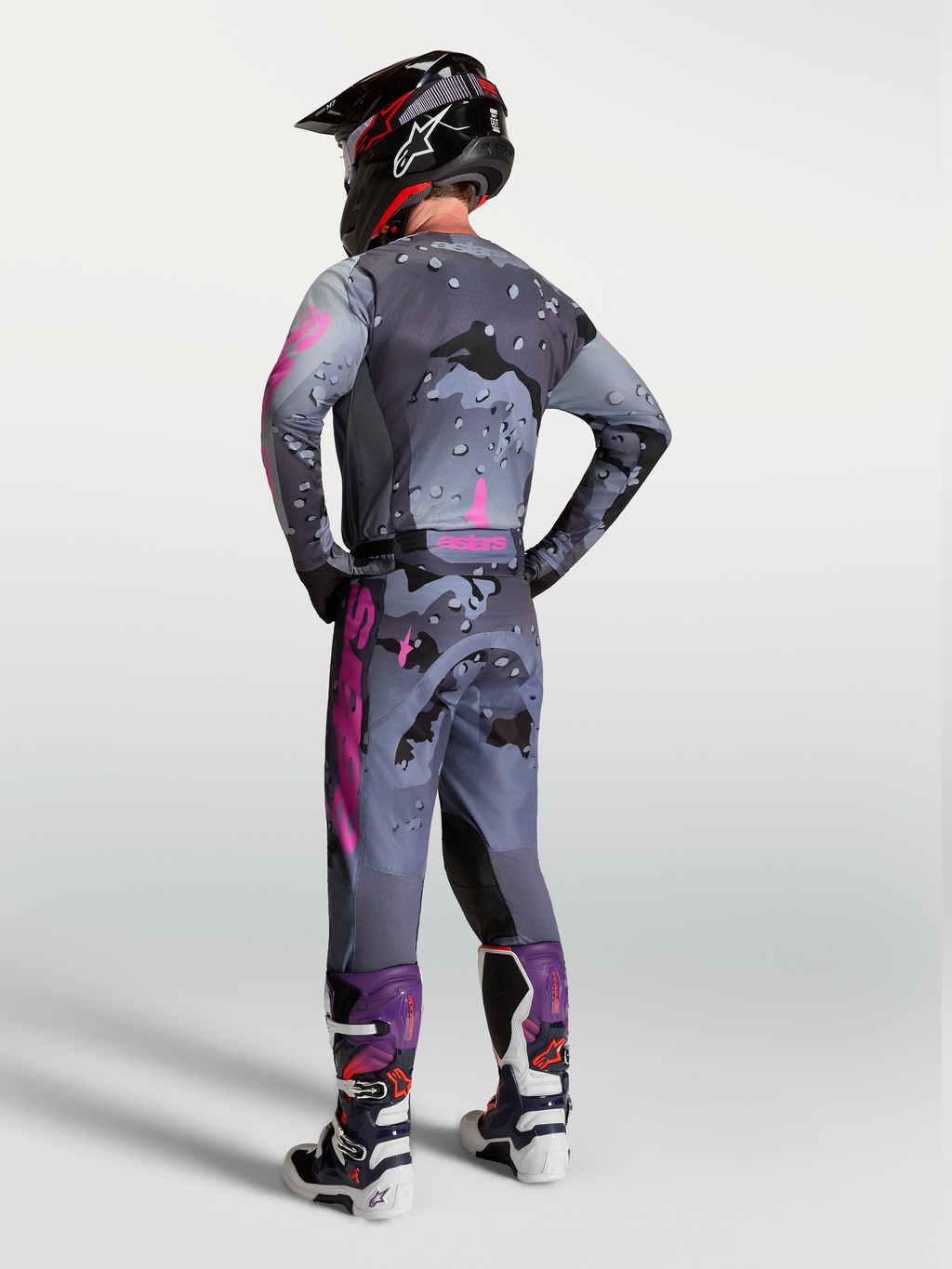 Alpinestars Racer Lone bukser, herre-motocrossudstyr, grå camo og lilla, set bagfra med matchende trøje og støvler.