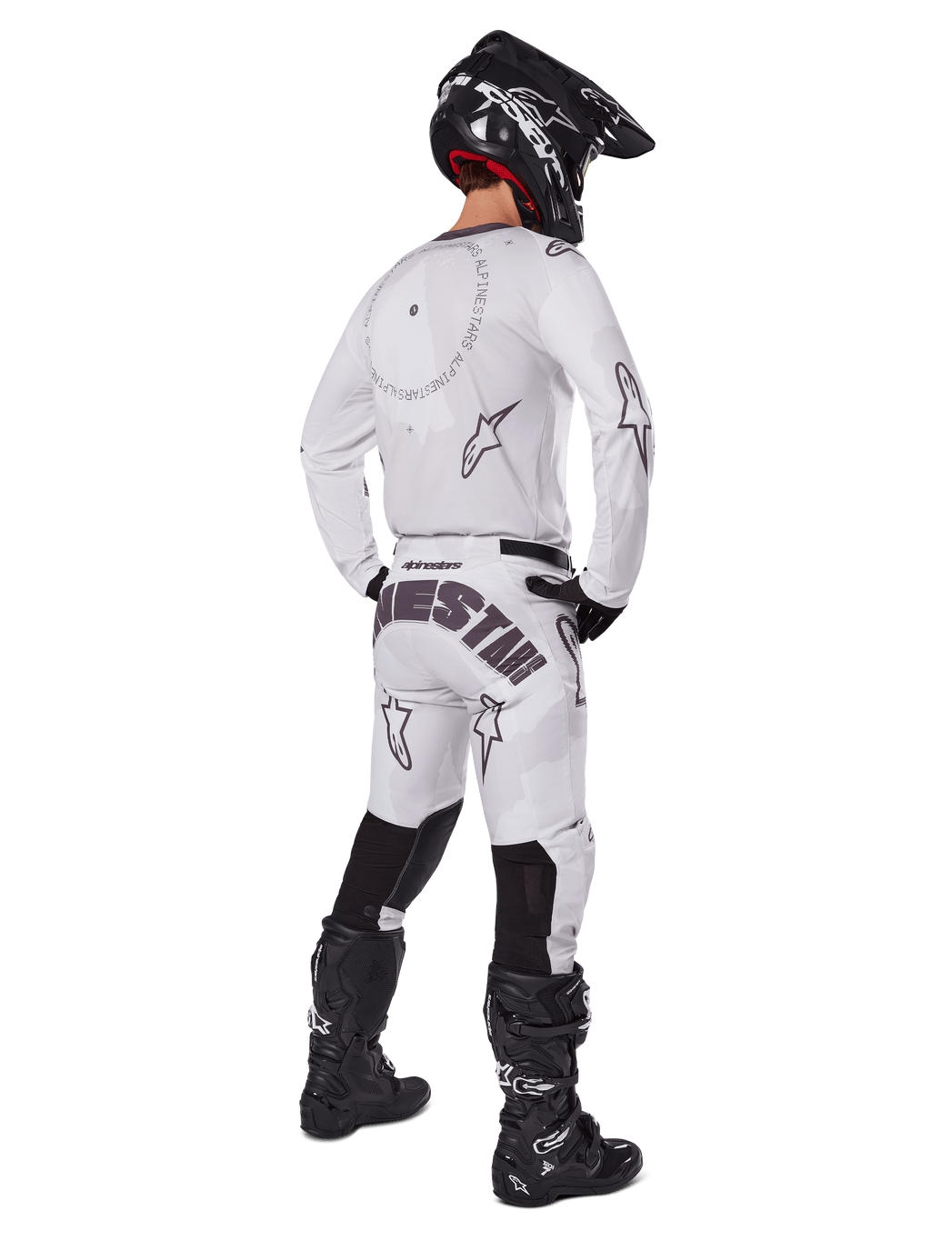Alpinestars 2025 Racer Hollow Gear Set, hvidt, set bagfra af en motocrosskører iført hvid trøje og bukser med sort branding, sort hjelm og sorte støvler, koordineret professionelt off-road raceroutfit