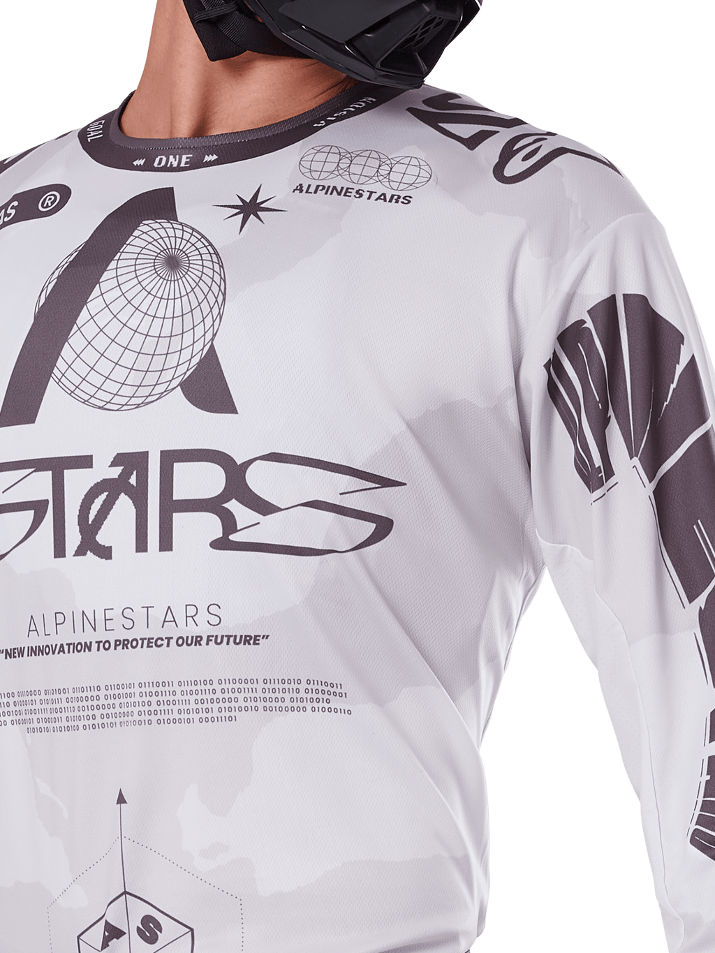 Nærbillede af Alpinestars 2025 Racer Hollow Jersey, hvid og grå, med sorte grafiske print, globus-logo og binær kode, teknisk motocross-beklædning til off-road kørsel
