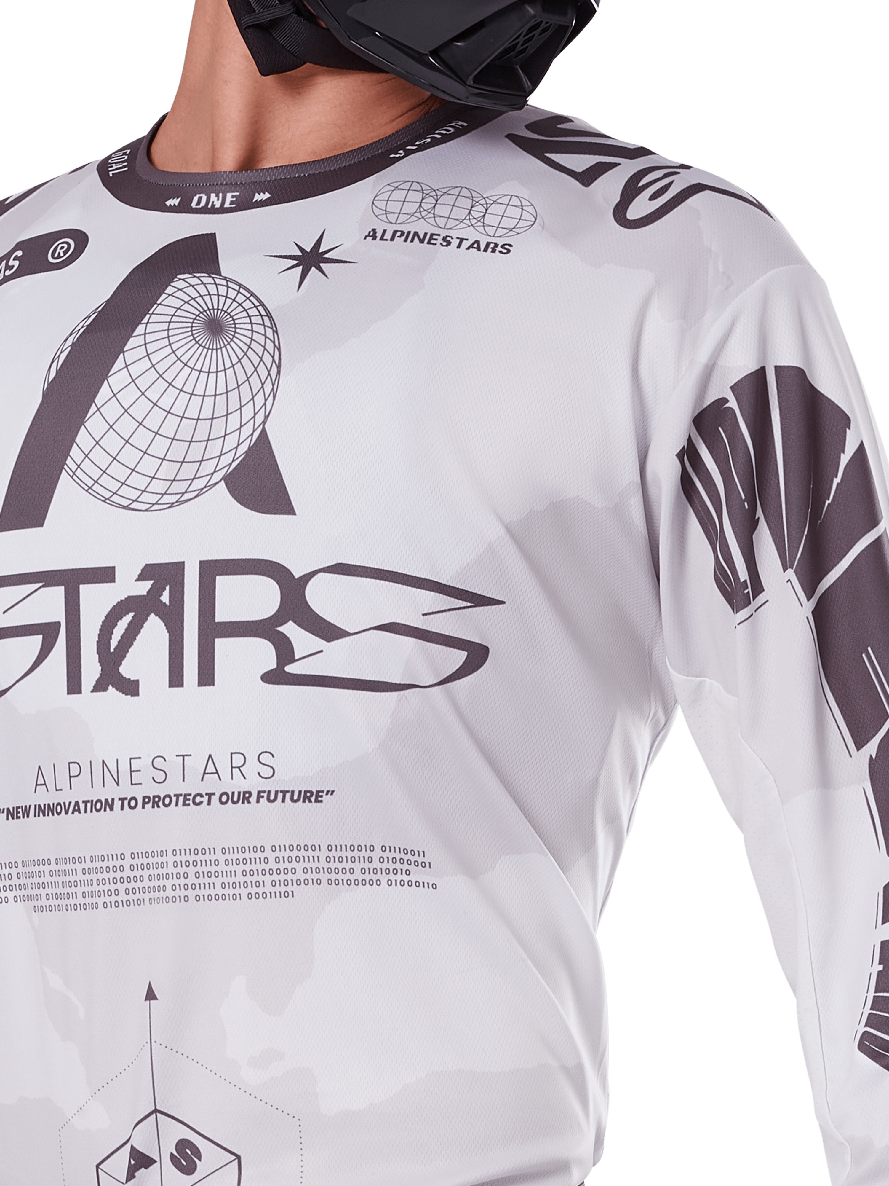 Nærbillede af Alpinestars 2025 Racer Hollow Jersey, hvid og grå, med sorte grafiske print, globus-logo og binær kode, teknisk motocross-beklædning til off-road kørsel