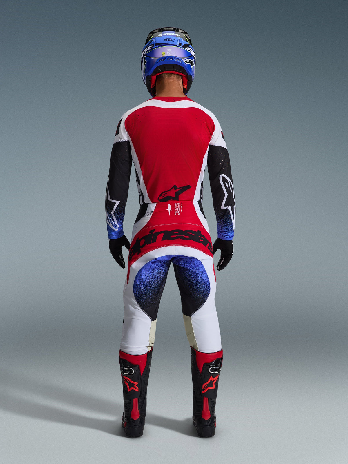 Alpinestars 2026 Techstar Knif trøje, motocross-trøje, sort, hvid og rød, set bagfra på en kører iført matchende bukser og udstyr, markant rødt rygpanel, hvide bukser med blå gradueringer og rød branding, professionelt off-road racingsæt
