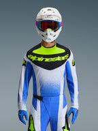 Alpinestars 2026 Techstar Knif udstyrssæt, motocross-kører iført blåt, hvidt og neongult racerudstyr, jersey med sort brystpanel og neongult logo, hvid hjelm med flerfarvede briller, matchende blå handsker og bukser, højtydende atletisk raceroutfit til terrænkørsel