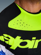 Nærbillede af Alpinestars 2026 Techstar Knif Jersey, sort og gul fluo, der fremhæver laserskårne perforeringer til ventilation, sømløs bundet krave og teknisk fugttransporterende stof med gul branding.