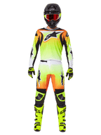 Motocross rider wearing complete racing gear, Alpinestars 2025 Fluid Wurx Gear Set, Yellow and Black with orange and white accents, jersey with large front logo, matching pants, black helmet with red-tinted goggles, neon yellow boots, coordinated outfit for off-road racing