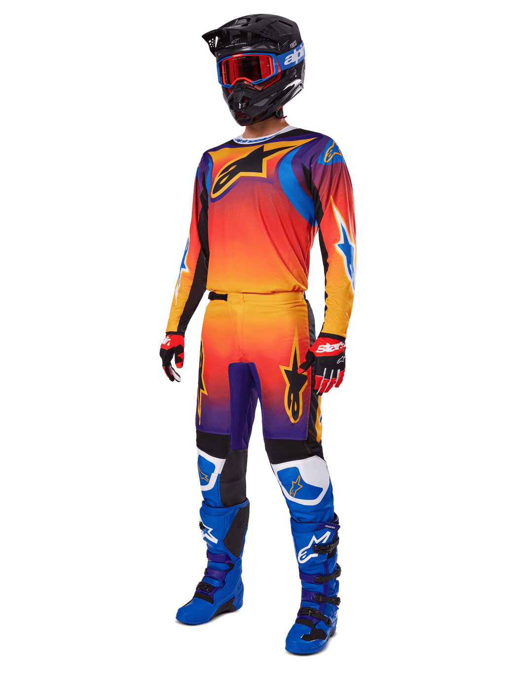 2025 Fluid Wurx Gear Set, motocross-trøje og -bukser med orange, rød og lilla farveovergang og blå og gule stjernedesigns, båret med sort hjelm, røde goggles, rød-sorte handsker og blå støvler, racingudstyr med høj synlighed