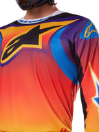 Alpinestars 2025 Fluid Wurx trøje, flerfarvet hvidt og orange design, langærmet motocross-trøje, afslappet atletisk pasform, fugttransporterende poly-materiale til off-road præstation