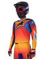 Alpinestars 2025 Fluid Wurx-udstyrssæt, motocross-udstyr, orange, lilla og blå farveovergang, med et stort sort A-stars-logo, båret med sort hjelm og blå goggles, koordineret outfit til professionel off-road racing