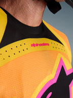 Alpinestars 2026 Techstar Nomur Jersey, Motocross Jersey, Orange Yellow Pink, close-up detail of the chest and collar, featuring laser-cut ventilation, pink branding, and breathable mesh fabric