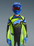 Motocross-kører iført Alpinestars 2026 Techstar Nomur trøje i mørkeblå og gul fluo med blå detaljer, med et stort blåt logo på brystet, matchende blå hjelm og goggles, koordineret racerudstyr til terrænkørsel
