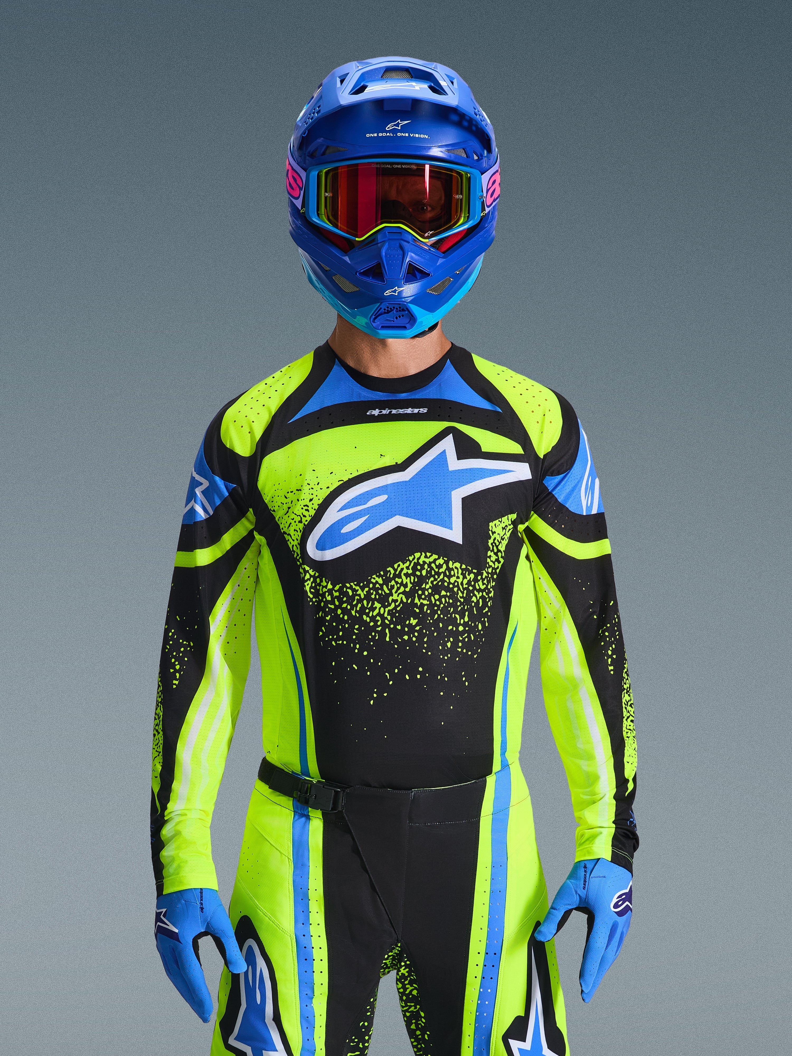 Motocross-kører iført Alpinestars 2026 Techstar Nomur trøje i mørkeblå og gul fluo med blå detaljer, med et stort blåt logo på brystet, matchende blå hjelm og goggles, koordineret racerudstyr til terrænkørsel