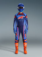 Motocrossrytter iført Alpinestars 2026 Techstar Nomur trøje i mørkeblå, orange og UCLA Blue, kombineret med matchende motocrossbukser, en blå hjelm med goggles og lysorange racingstøvler, komplet koordineret off-road konkurrenceudstyr