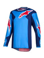 Alpinestars 2026 Fluid Grid trøje, motocrosstrøje, blå og rød, med store røde Alpinestars-stjernelogoer, mørkeblå sidepaneler og letvægts poly-tekstilkonstruktion med en forlænget ryg til off-road kørsel.