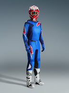 Motocross-kører iført Alpinestars 2026 Fluid Grid Jersey i Blue Red, kombineret med matchende motocrossbukser, hvide og sorte støvler og en rød og hvid hjelm, professionelt udstyrssæt til terrænkørsel.