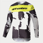 Alpinestars 2023 Racer Tactical trøje, motocross-trøje, Cast Gray Camo og Yellow Fluo, med gråt og sort camouflagemønster, et lysende gult brystpanel og Alpinestars-logo, slidstærkt langærmet performance-gear til off-road racing