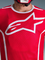 Alpinestars 2026 Fluid Apex Jersey, rød og hvid, nærbillede af brystet med stort hvidt Astars-logo, hvid sportskrave og fugttransporterende materiale til motocross-ydeevne