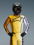 Alpinestars 2026 Fluid Apex trøje, motocross-trøje, gul og sort med et hvidt ærme og stort sort logo på brystet, båret som en del af et komplet racersæt med matchende bukser, sort hjelm og handsker