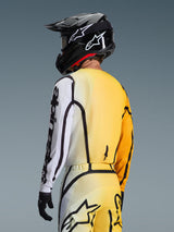 Trekvart-visning bagfra af en motocrosskører iført 2026 Fluid Apex Jersey i Yellow Black, med et gradientdesign fra gul til hvid, tydelig sort Alpinestars-branding på ærmet, båret med matchende bukser og en sort motocrosshjelm.