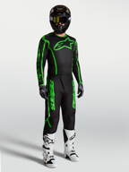 Alpinestars Fluid Apex V2 bukser, herre-motocrossudstyr, sort og fluorescerende grøn, vist med hvide støvler.