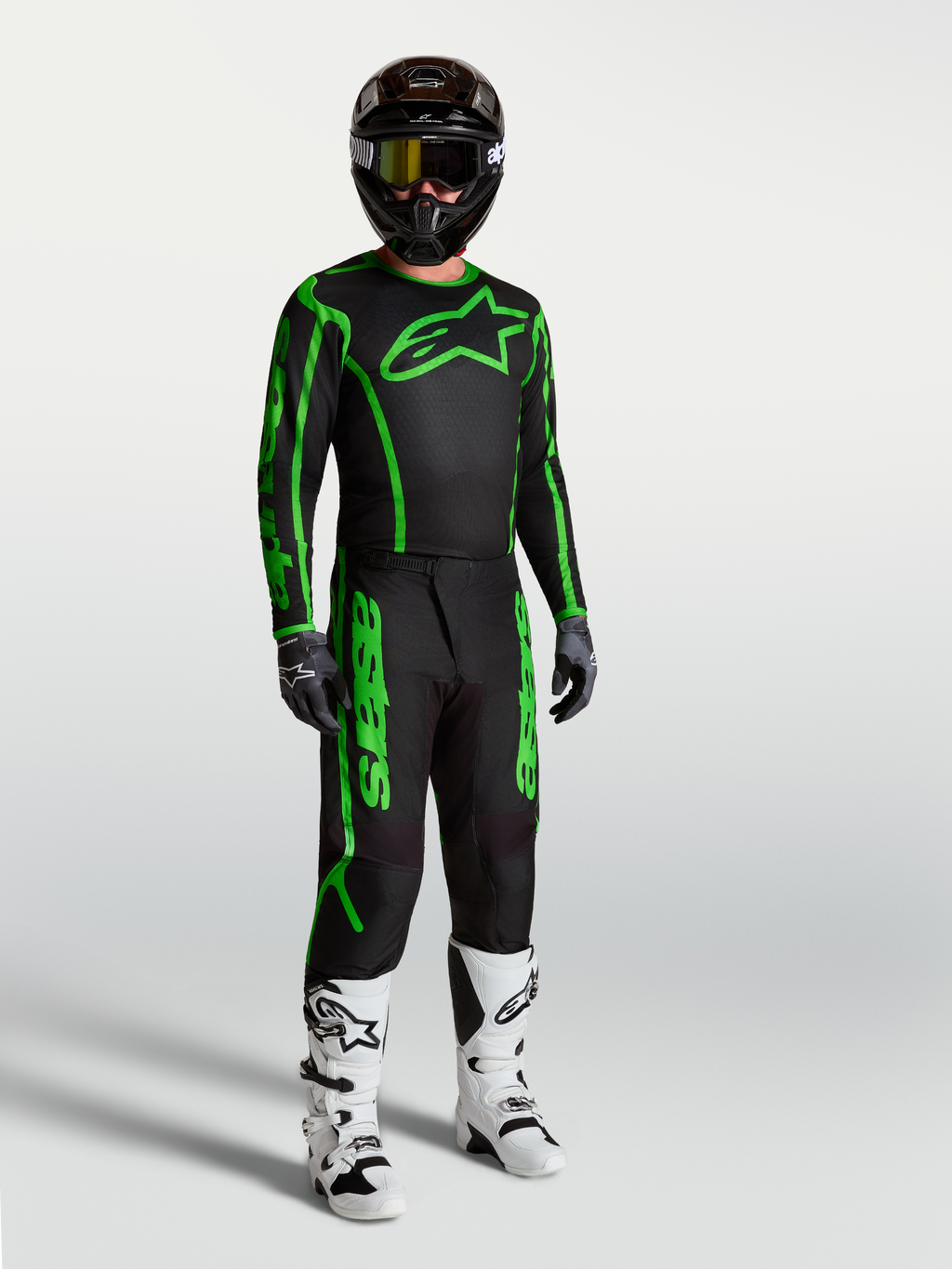 Alpinestars Fluid Apex V2 trøje, motocrosstrøje til herrer, sort og grøn, vist på model med matchende bukser og støvler.