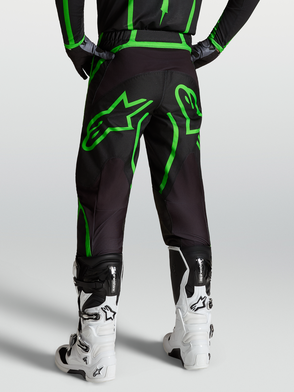 Alpinestars Fluid Apex V2 bukser, motocross- og off-road herrebukser, sort og grøn, set bagfra på model med hvide støvler