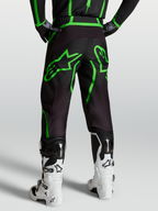 Alpinestars Fluid Apex V2 bukser, motocross- og off-road herrebukser, sort og grøn, set bagfra på model med hvide støvler