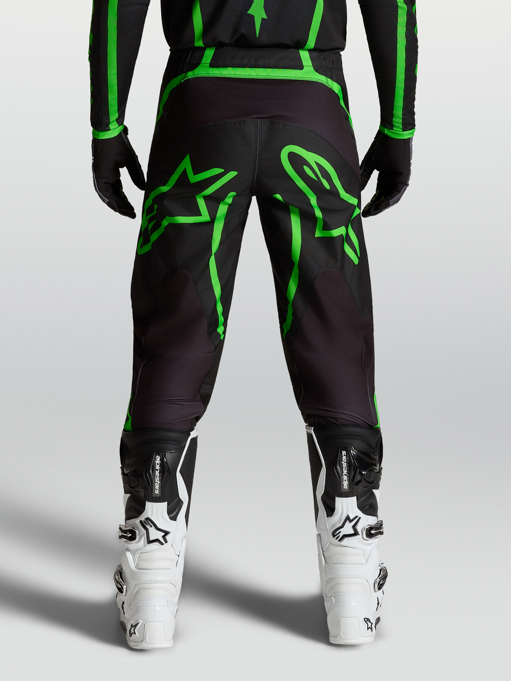 Alpinestars Fluid Apex V2 Bukser, herre-motocrossbukser, sort og neon grøn, set bagfra på model med stjerne-grafik