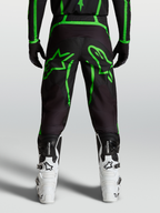 Alpinestars Fluid Apex V2 Bukser, herre-motocrossbukser, sort og neon grøn, set bagfra på model med stjerne-grafik
