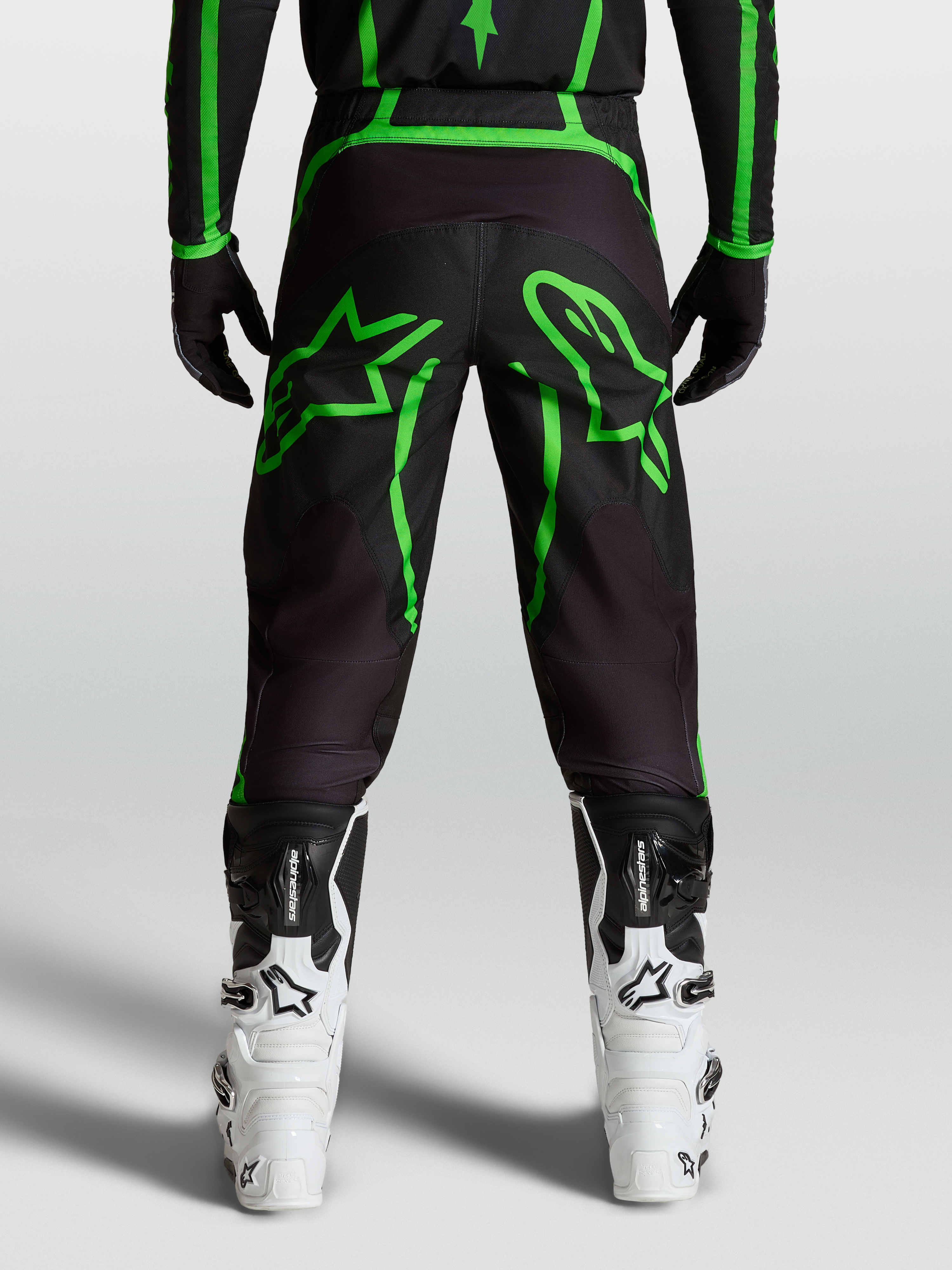 Alpinestars Fluid Apex V2 Bukser, herre-motocrossbukser, sort og neon grøn, set bagfra på model med stjerne-grafik
