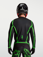 Alpinestars Fluid Apex V2 trøje, motocrosstrøje til herrer, sort og grøn, bagfra på model med forlænget rygstykke til MX.