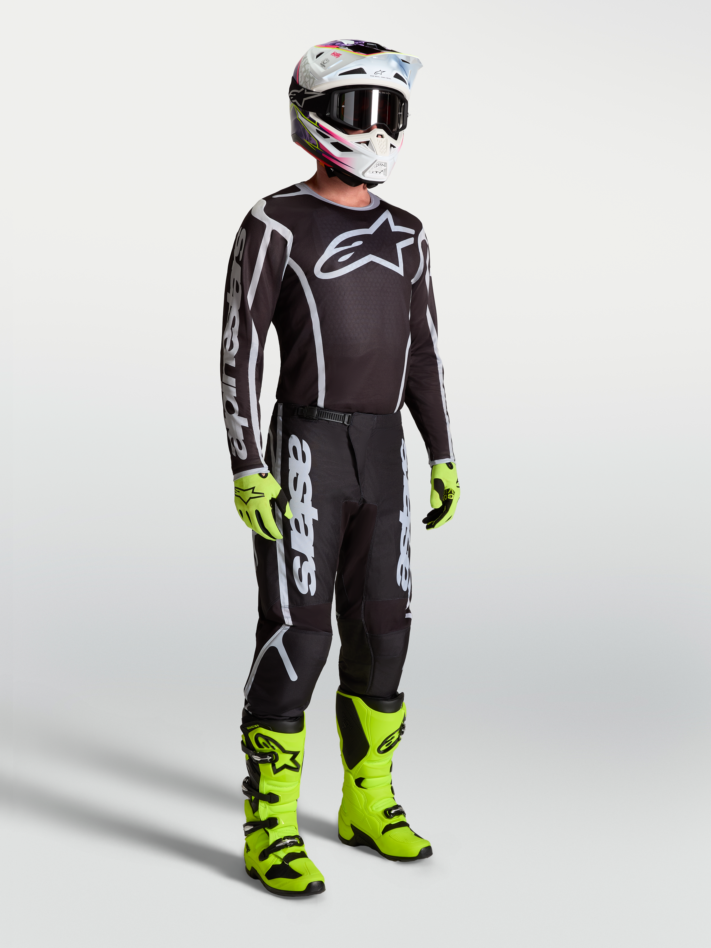 Alpinestars Fluid Apex V2 trøje, sort og sølv motocrosstrøje til herrer på model med neongrønne støvler og handsker.