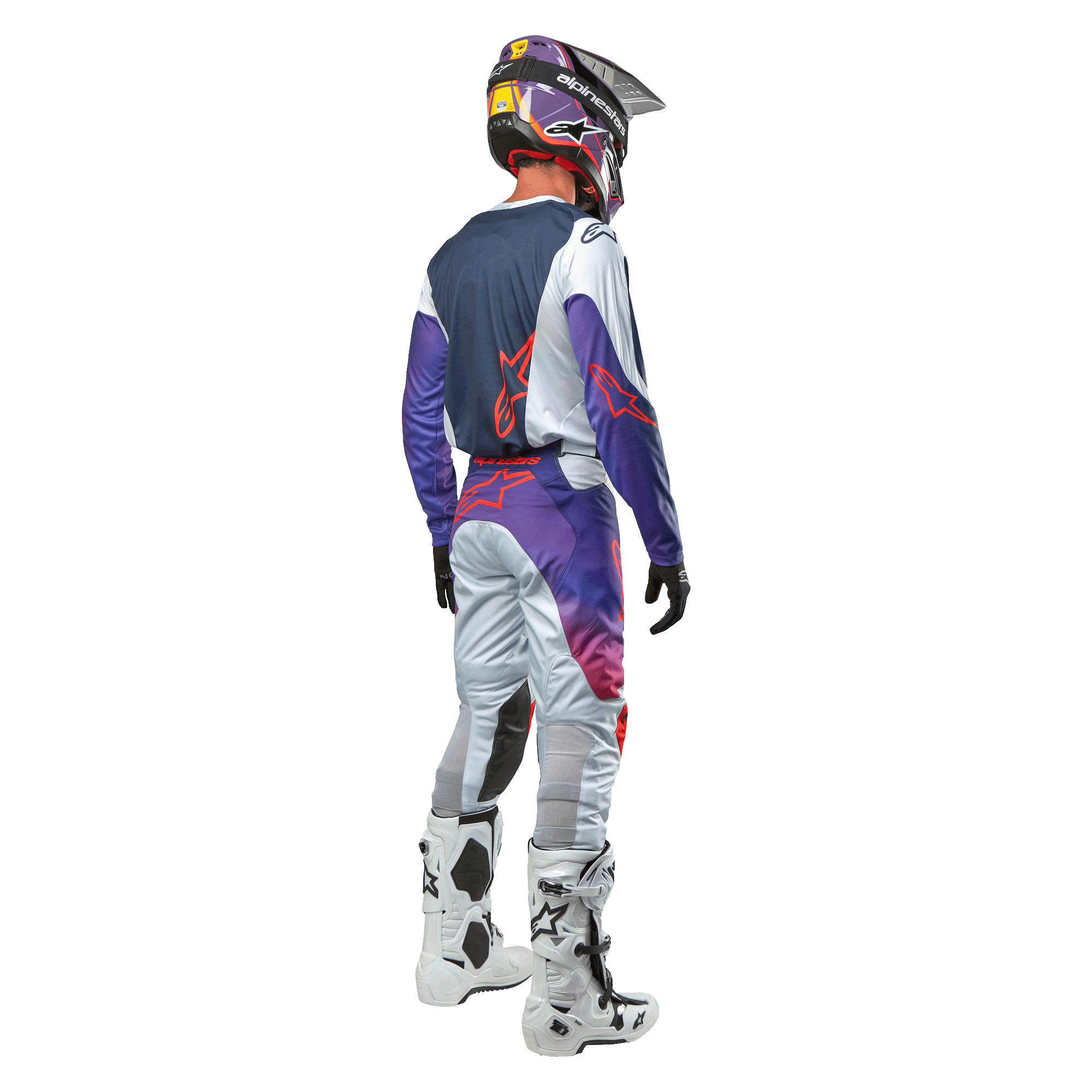 Motocrosskører set bagfra iført Alpinestars 2024 Racer Hoen Jersey i farven Light Gray Hot Orange Black, marineblåt rygpanel med orange stjernelogo, lilla ærmer, matchende racerbukser og hvide støvler.