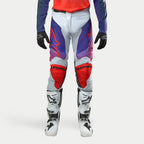 Alpinestars 2024 Racer Hoen bukser, motocross off-road bukser, lysegrå med hot orange og lilla gradientdetaljer, røde knæpaneler, frontvisning, herre, vist med hvide motorcykelstøvler og sorte handsker, beskyttelsesudstyr til terrænkørsel