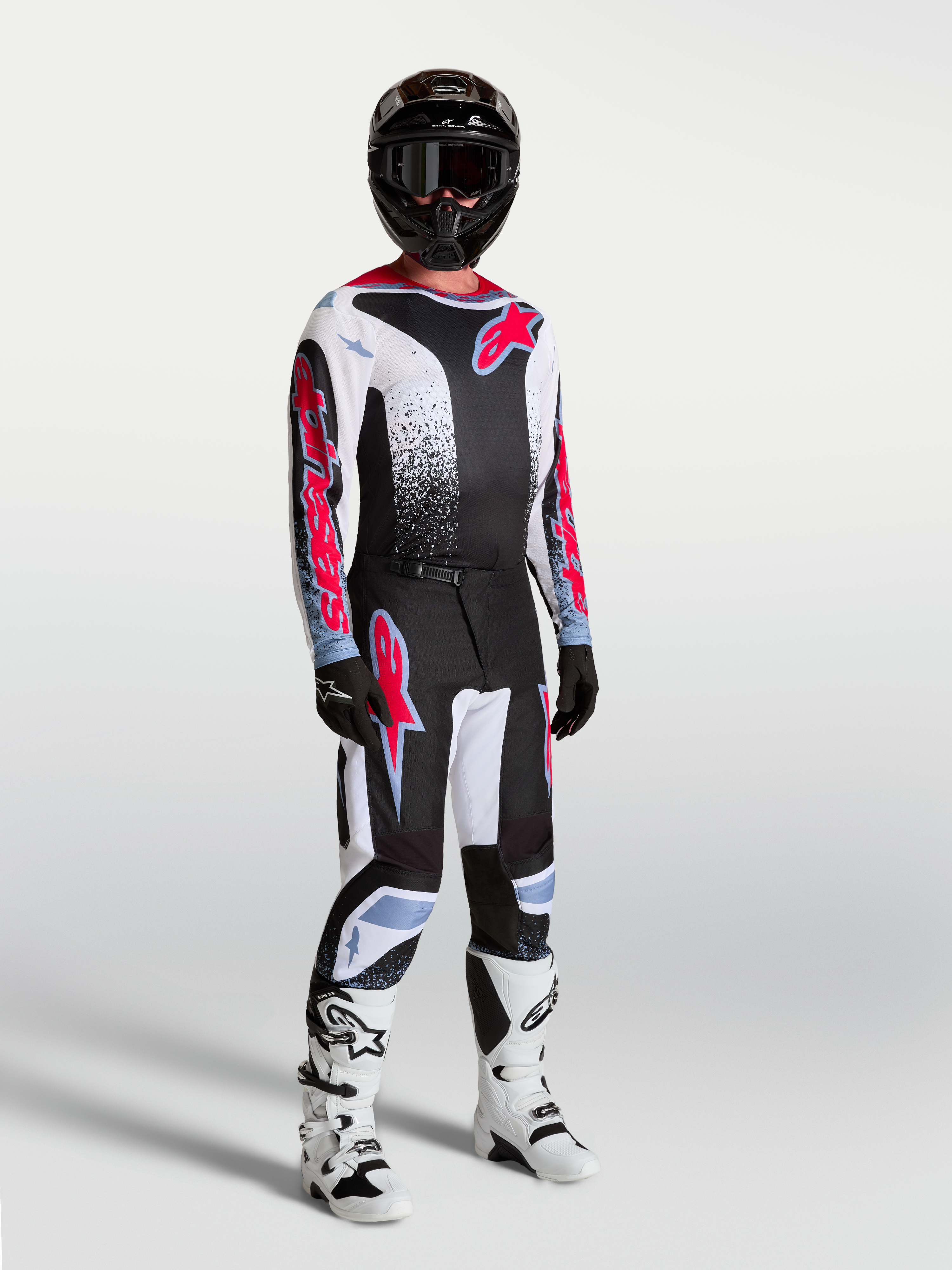 Alpinestars Fluid Drag trøje, herremotocrosstrøje i sort, hvid og rød fluo, åndbart poly-stof på model med fuldt udstyr