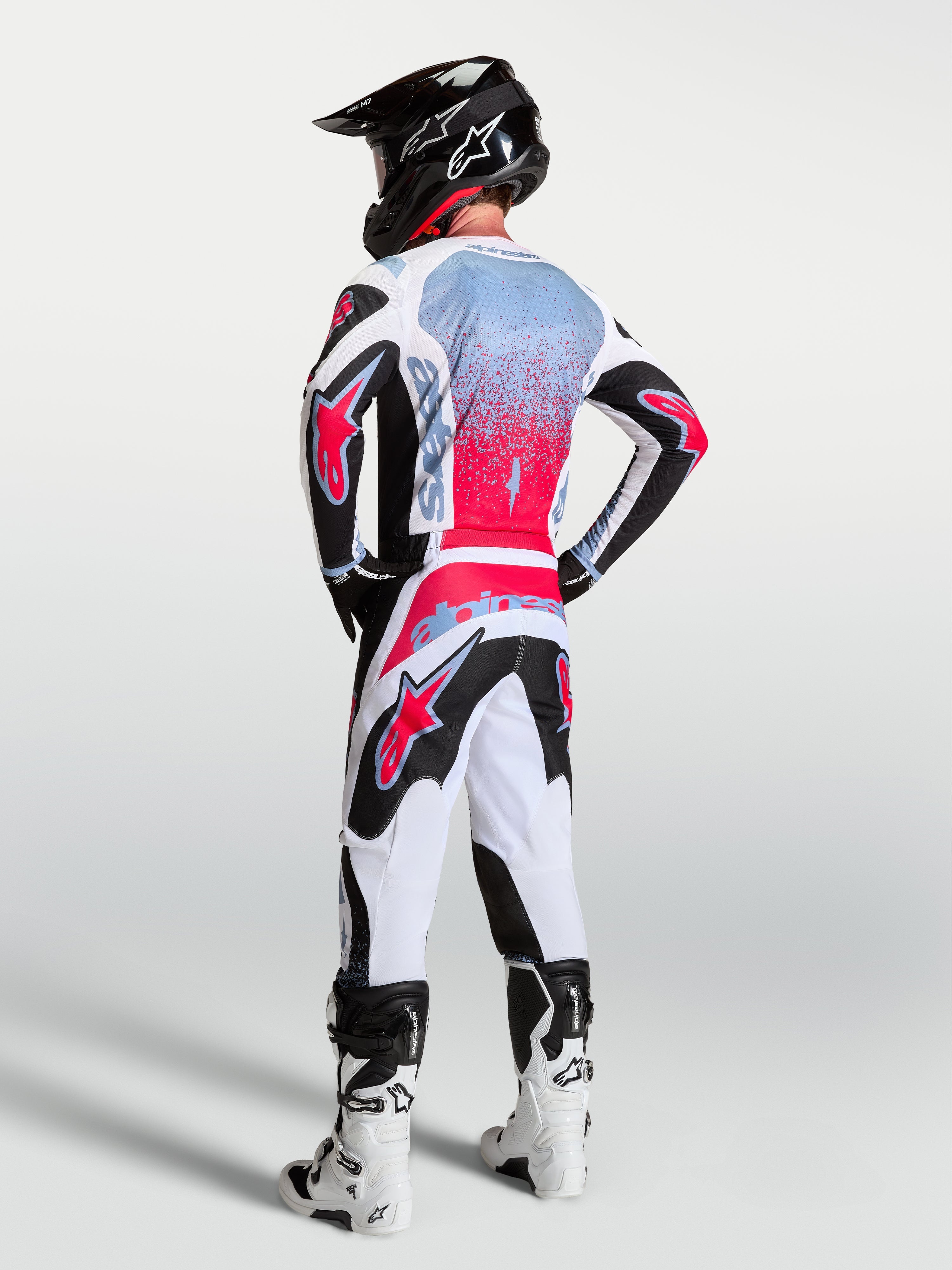 Alpinestars 2027 Fluid Drag Gear Sæt, herre-motocrossudstyr i sort, hvid og rød med spray-effekt grafik, set bagfra