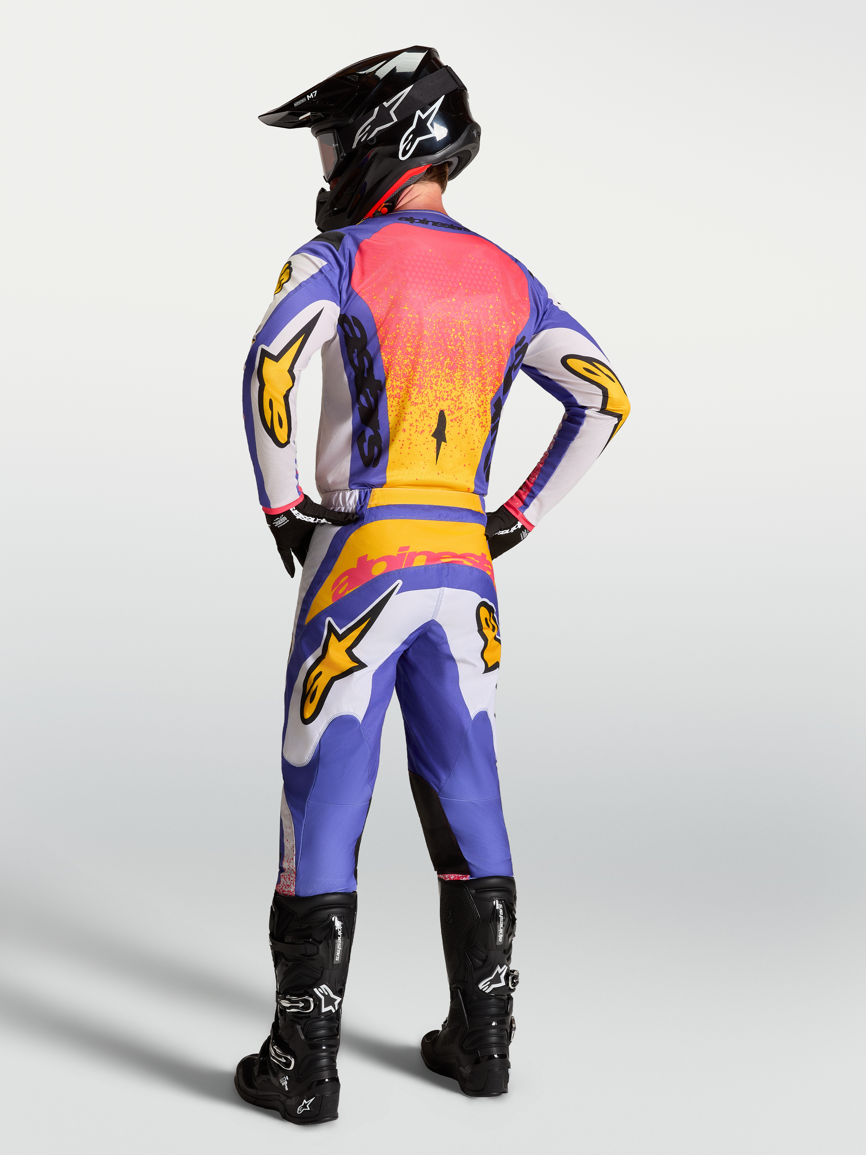 Alpinestars Fluid Drag herre-motocrossudstyrssæt i blå, lys lilla og iris guld, set bagfra på model.