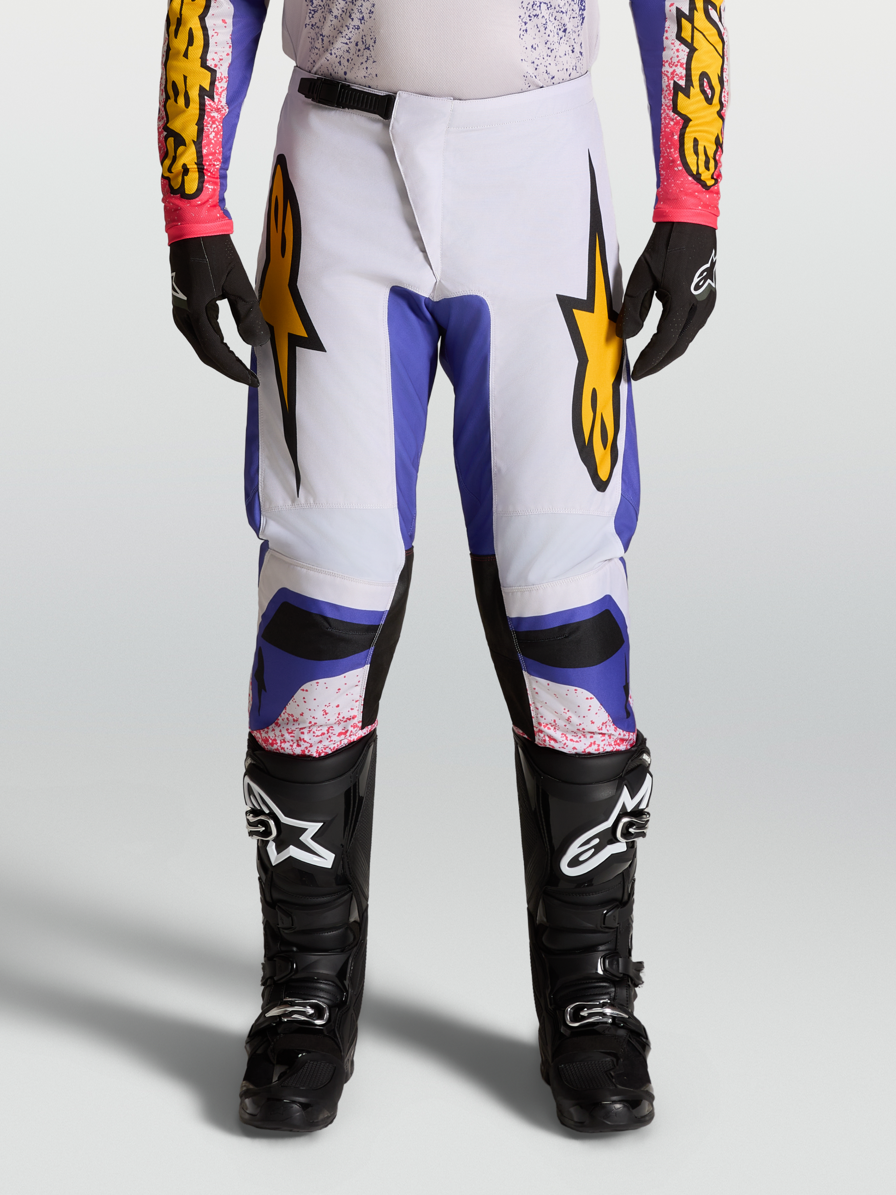 Alpinestars 2027 Fluid Drag Pants, men's motocross racing pants in light lilac and blue iris with gold accents.