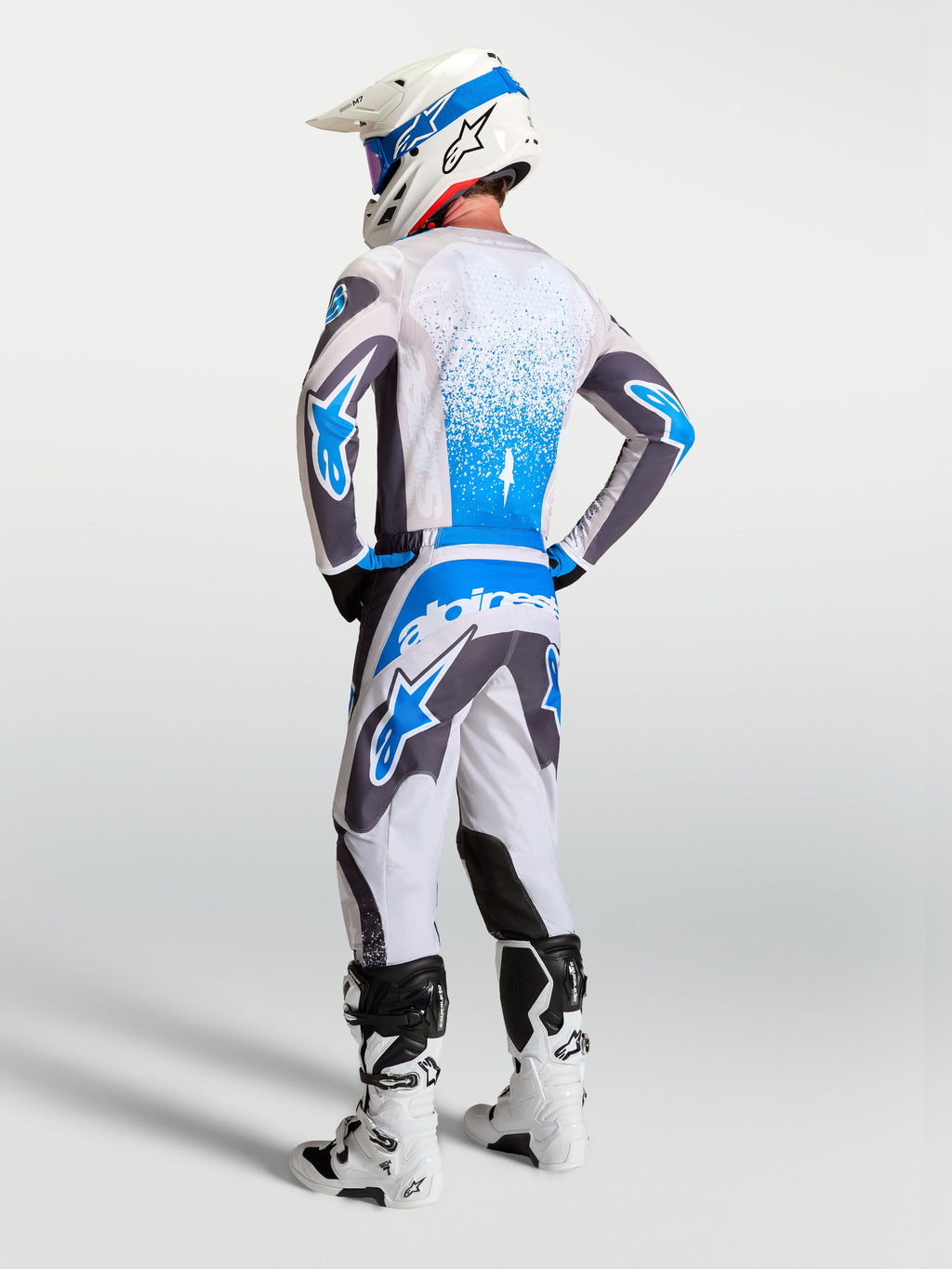 Alpinestars 2027 Fluid Drag Gear Sæt, herre-motocross-trøje og -bukser i grå og blå, rygsyn af teknisk MX-udstyr.