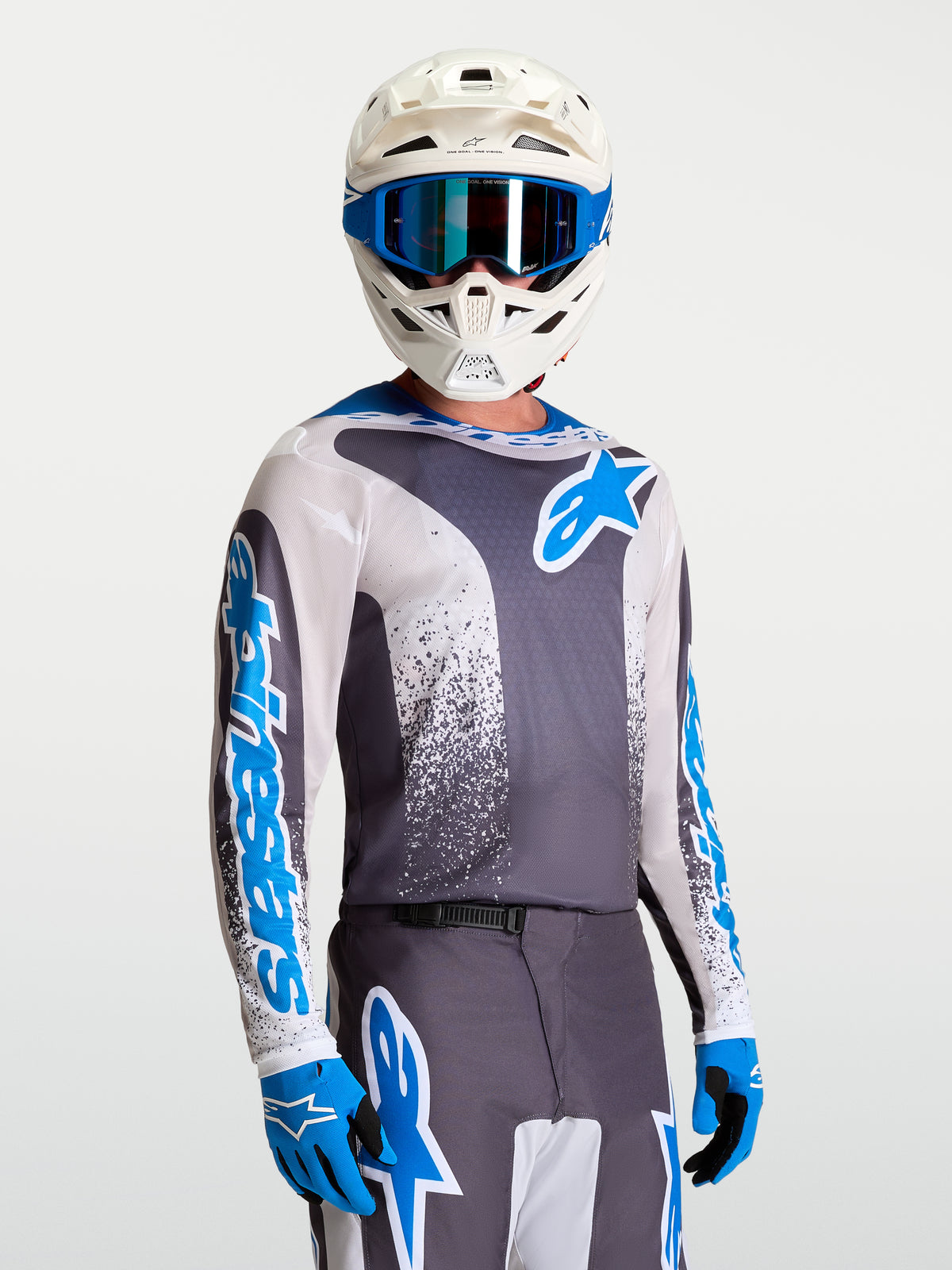 Alpinestars Fluid Drag Jersey, Gray and Blue performance motocross jersey on-model with white helmet and gloves.