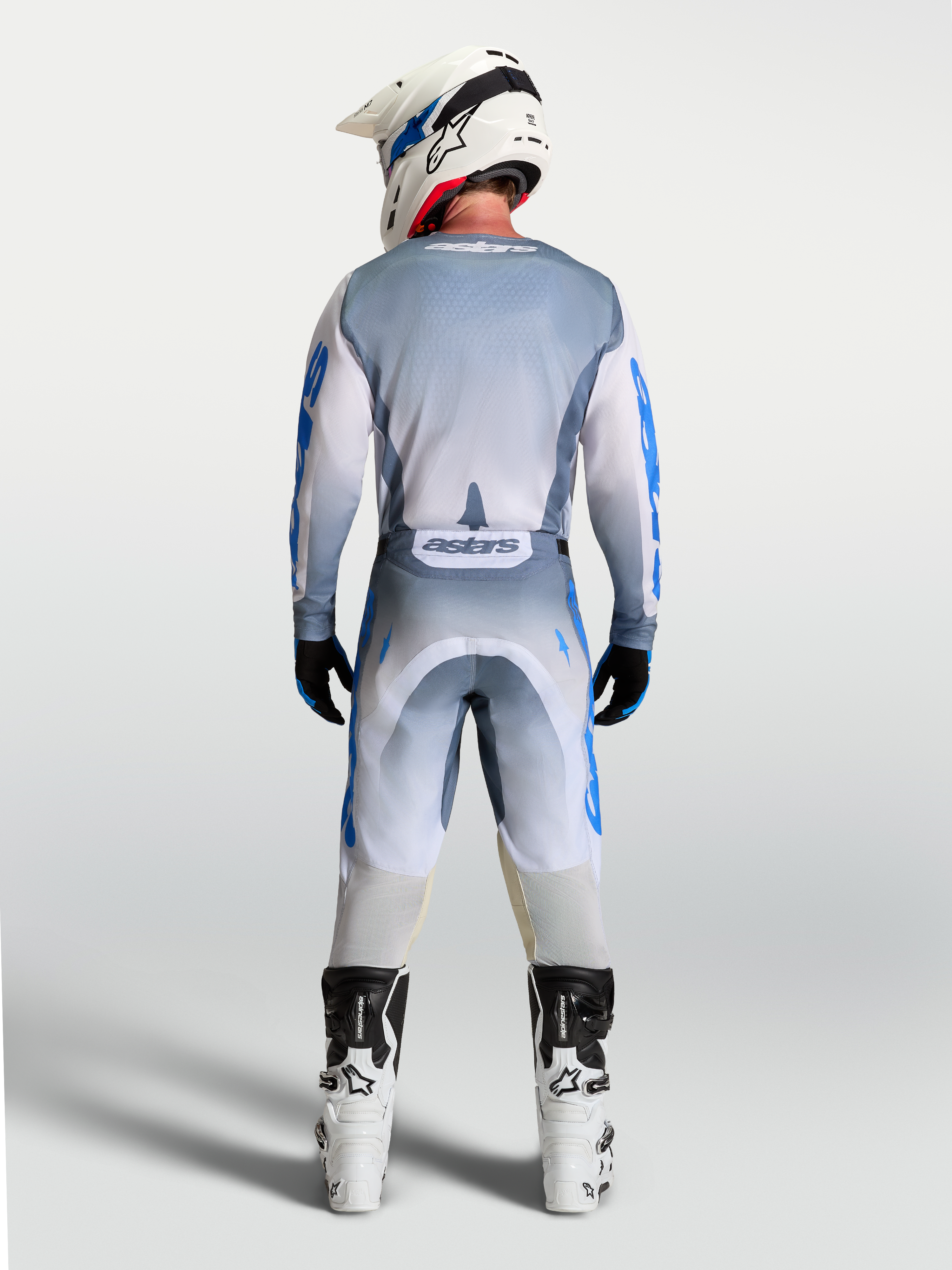 Alpinestars Racer Amber trøje, herre-motocrosstøj i grå og blå, vist i fuld profil bagfra på en model.