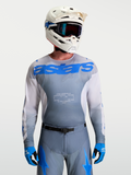 Alpinestars Racer Amber Trøje, herre motocross-udstyr i grå og blå, kombineret med hvid MX-hjelm og goggles.