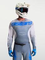 Alpinestars Racer Amber Trøje, herre motocross-udstyr i grå og blå, kombineret med hvid MX-hjelm og goggles.