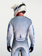 Alpinestars Racer Amber trøje, motocross trøje i grå og hvid, set bagfra på model med hvid hjelm, ergonomisk race pasform.