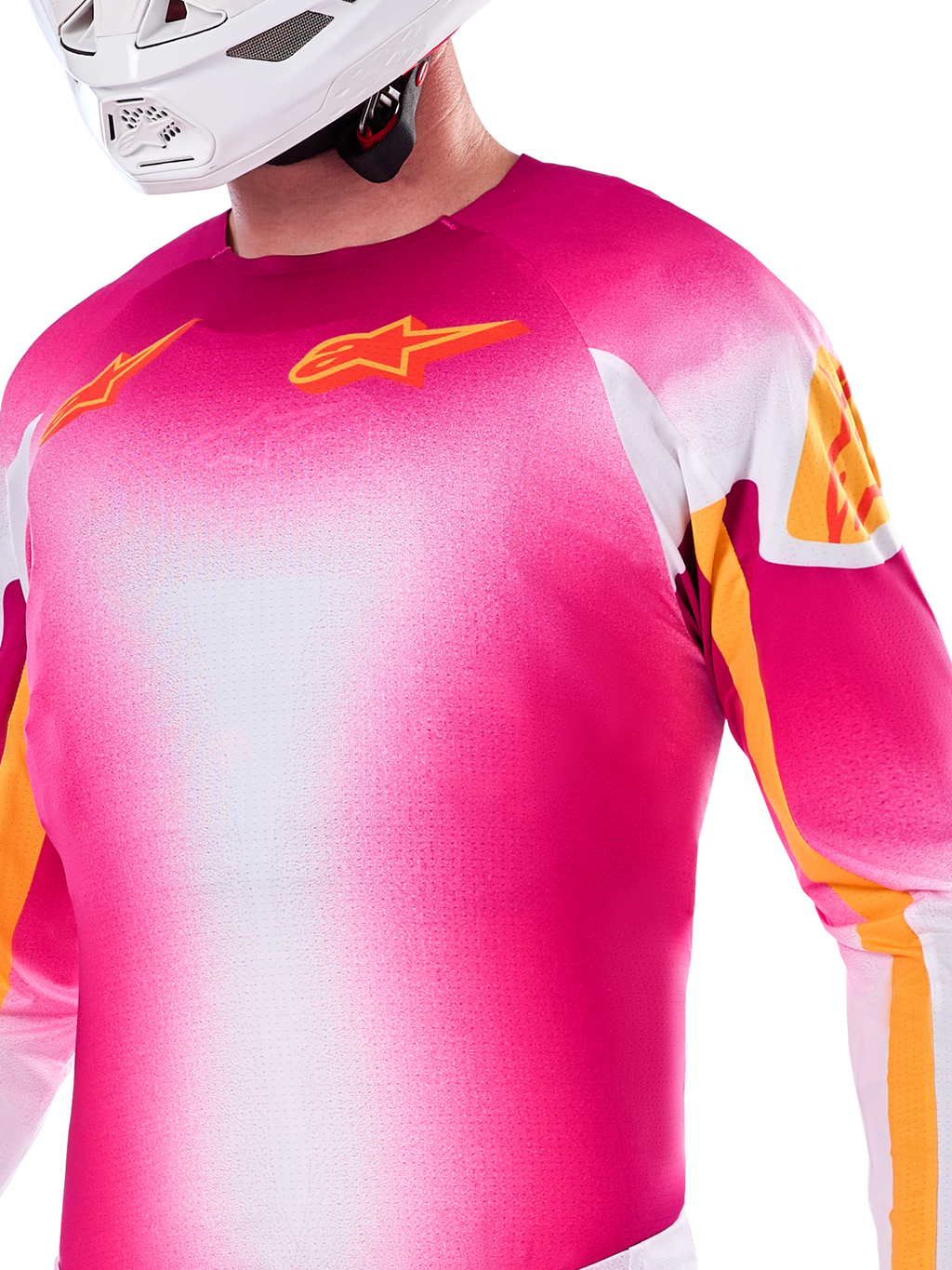 Alpinestars Limited Edition Supertech AFD MIG Jersey, motocross-jersey i pink fluo og hvid gradient, med orange Astars-logoer og ærmedetaljer, båret af en kører med hvid hjelm, atletisk racerpasform.