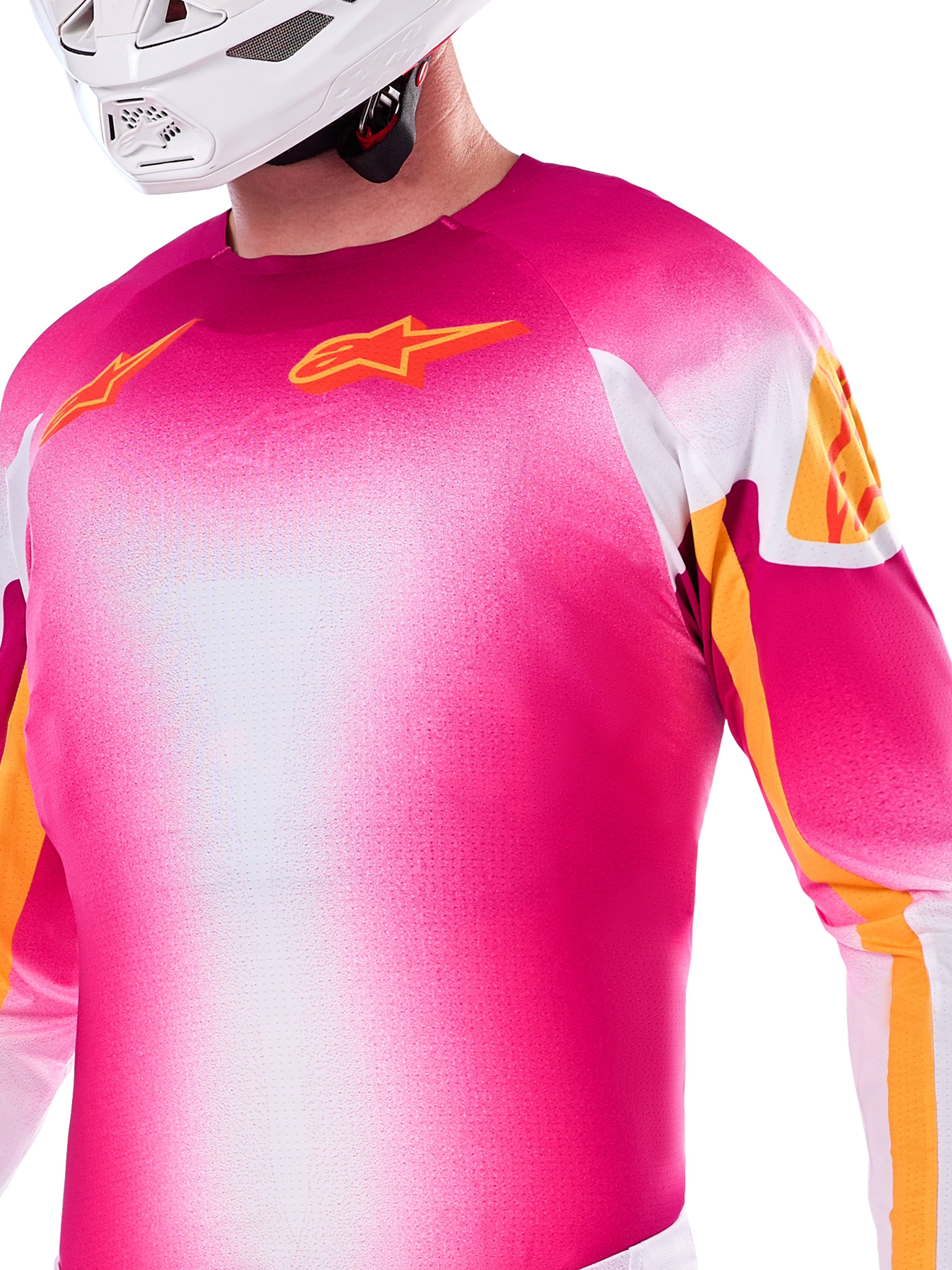 Alpinestars Limited Edition Supertech AFD MIG Jersey, motocross-jersey i pink fluo og hvid gradient, med orange Astars-logoer og ærmedetaljer, båret af en kører med hvid hjelm, atletisk racerpasform.