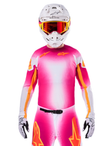 Motocross rider wearing the Alpinestars Limited Edition Supertech AFD MIG Jersey, Pink Fluo White gradient design with orange star logos, matching pants, white helmet, and red-tinted goggles, elite off-road racing apparel.