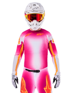 Alpinestars Limited Edition Supertech AFD MIG Jersey, lyserød fluo hvid motocross-trøje med en livlig farveovergang og orange stjernelogoer, her vist som et komplet racersæt med matchende bukser, hvid hjelm og røde briller, professionelt udstyr til terrænkørsel