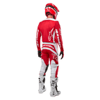 Rear view of a motocross rider wearing the Alpinestars 2024 Fluid Lurv Jersey in Mars Red White, paired with matching red and white pants, white off-road boots, and a red helmet, showing the jersey's back design and Alpinestars branding.