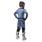 Motocross-rytter set bagfra iført Alpinestars 2024 Fluid Lurv-trøje og matchende bukser i lyseblå og sort, med sort branding på ryggen og ærmerne, kombineret med en sort hjelm og hvide støvler.